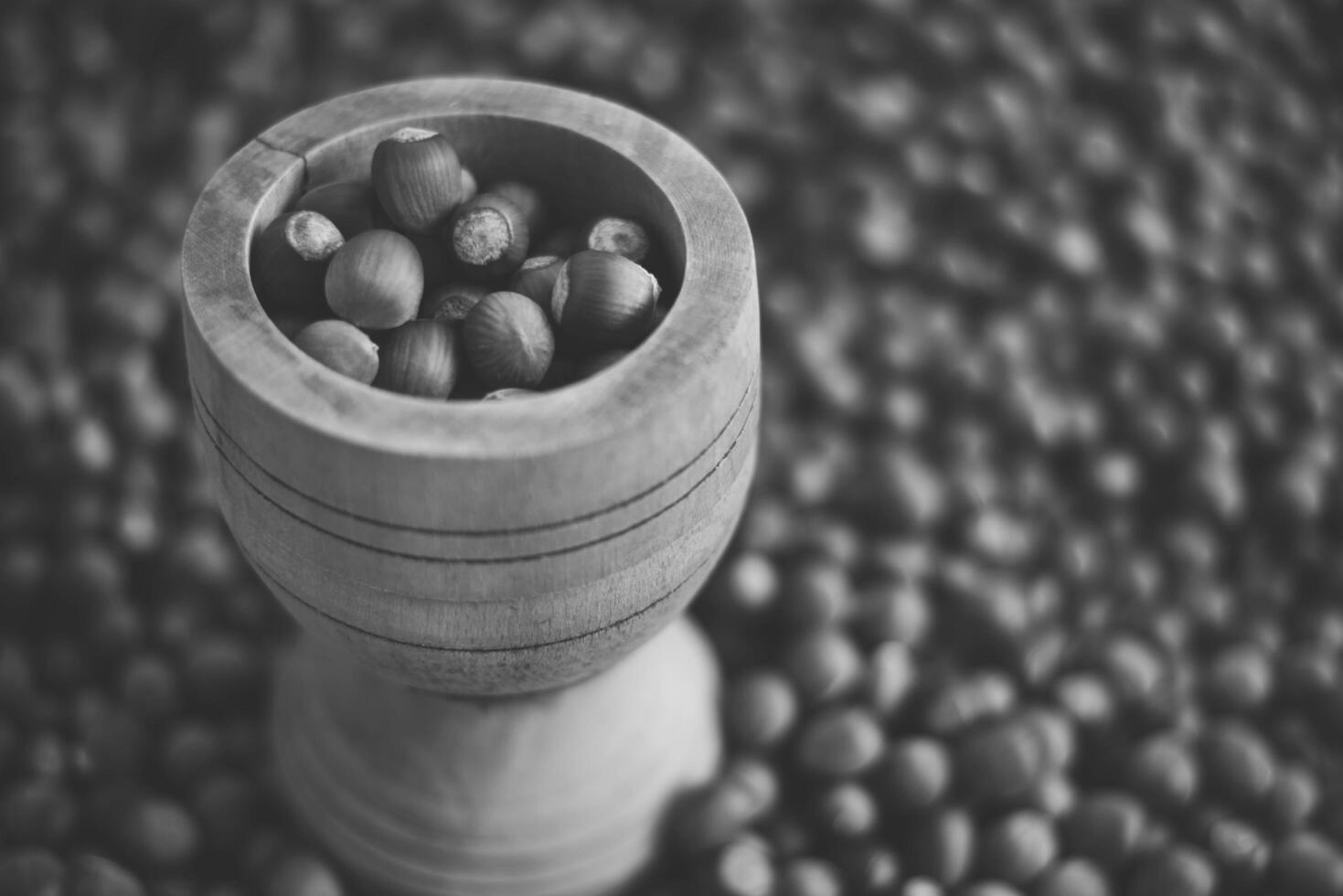 Hazelnuts in a wooden bowl on rustic background, Hazelnut background with green leaf photo
