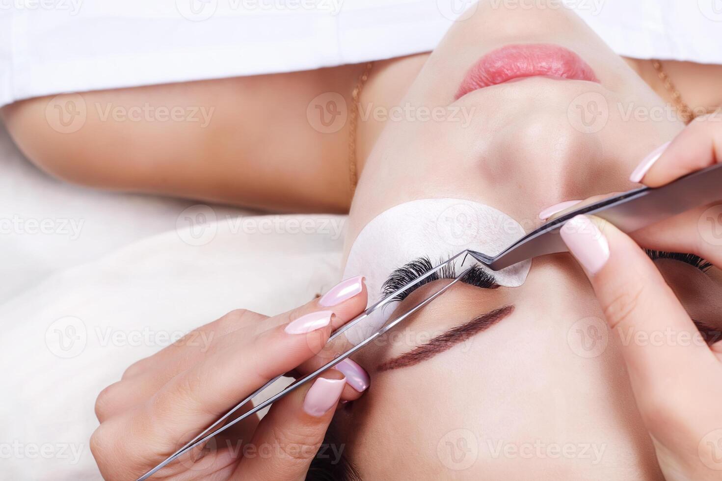 Eyelash Extension Procedure. Woman Eye with Long Eyelashes. Lashes, close up, macro, selective focus. photo