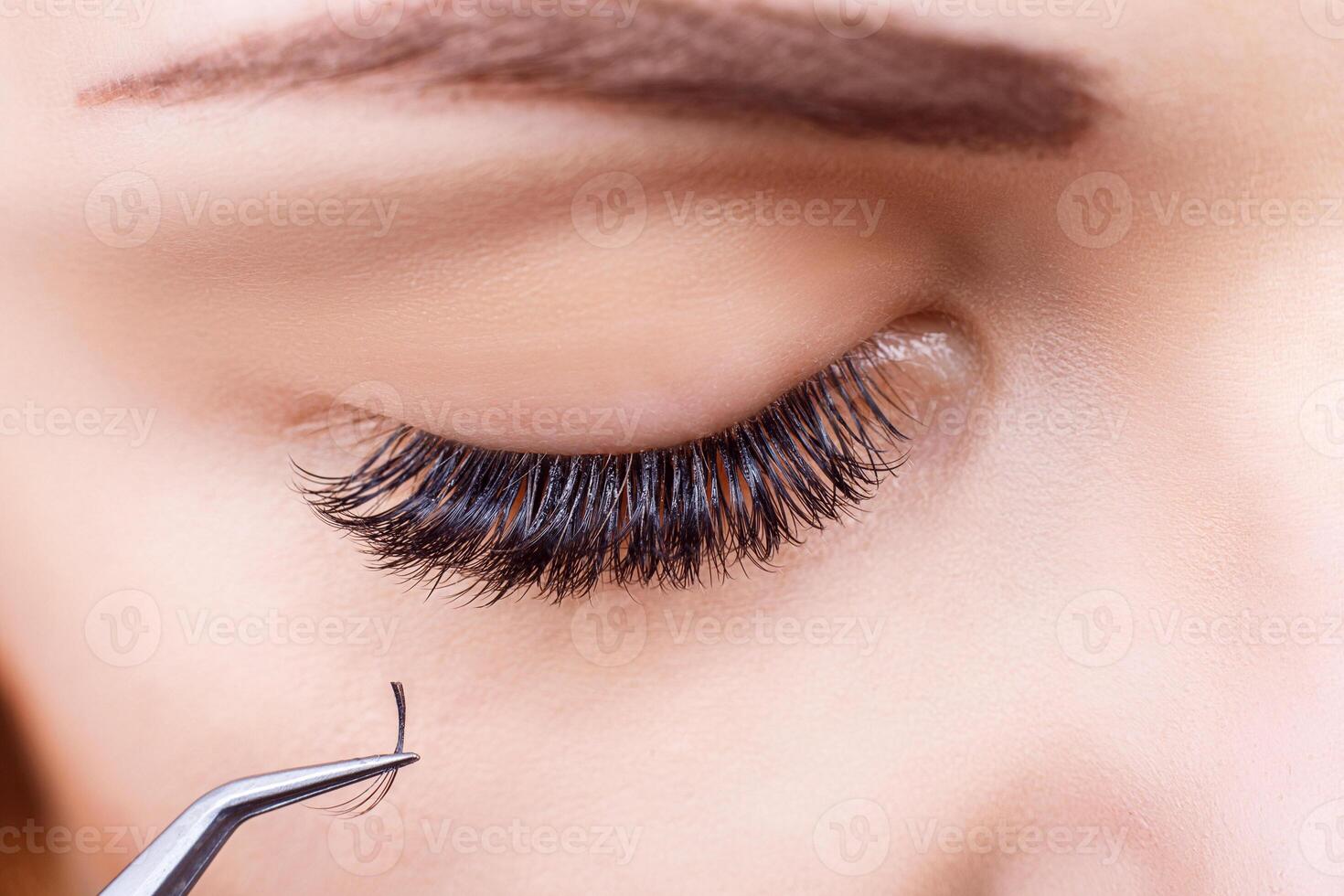 Eyelash Extension Procedure. Woman Eye with Long Eyelashes. Lashes, close up, macro, selective focus. photo