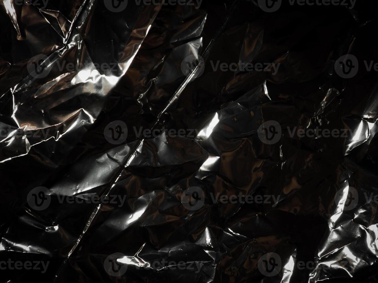 Silver foil in the dark for a mysterious abstract background. photo
