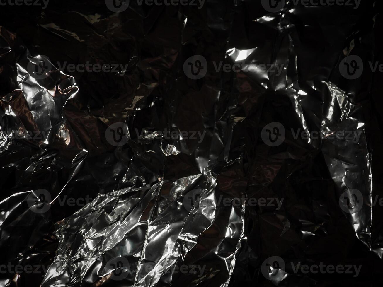 Silver foil in the dark for a mysterious abstract background. photo