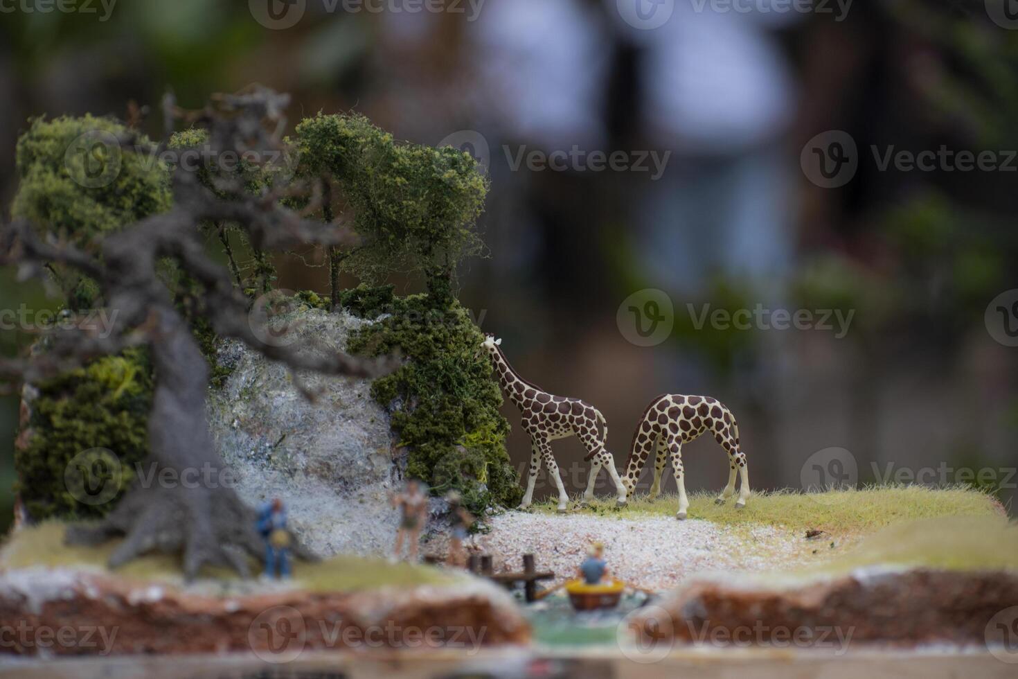 Macro photography of two toy giraffes grazing. Toy photography concept with bokeh background. photo