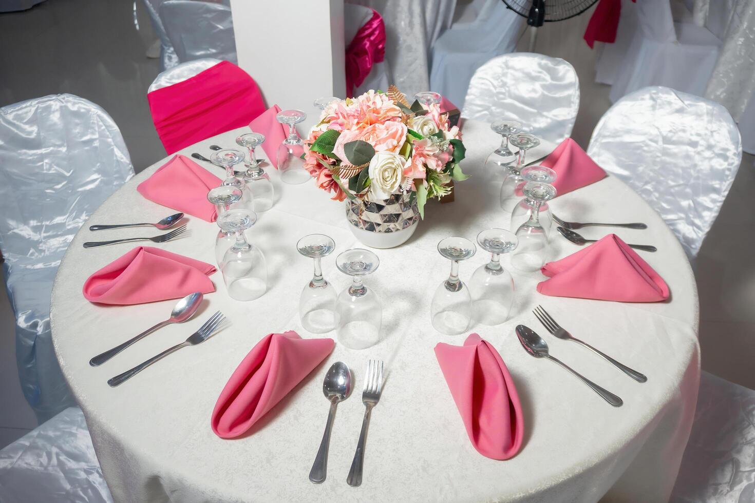 A table with pink napkins and silverware photo