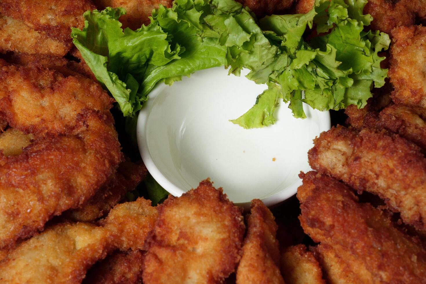 a plate of fried chicken with a side of lettuce photo
