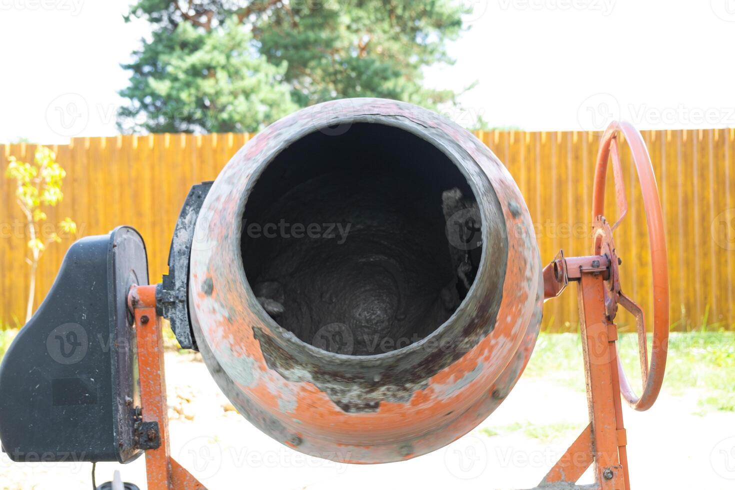 Mixing mortar in a handheld portable concrete mixer photo