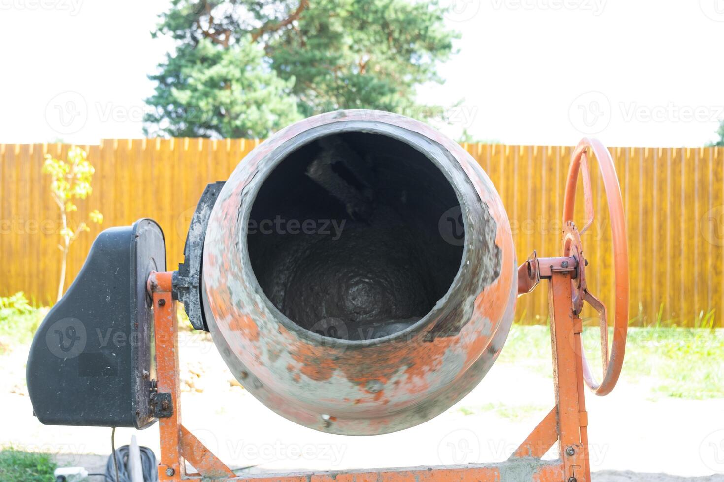 Mixing mortar in a handheld portable concrete mixer photo