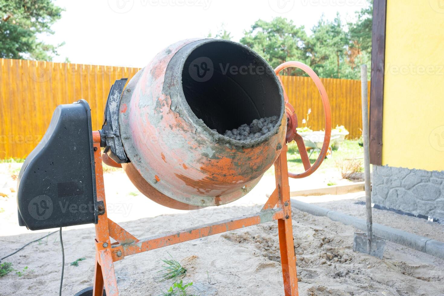 Mixing mortar in a handheld portable concrete mixer photo