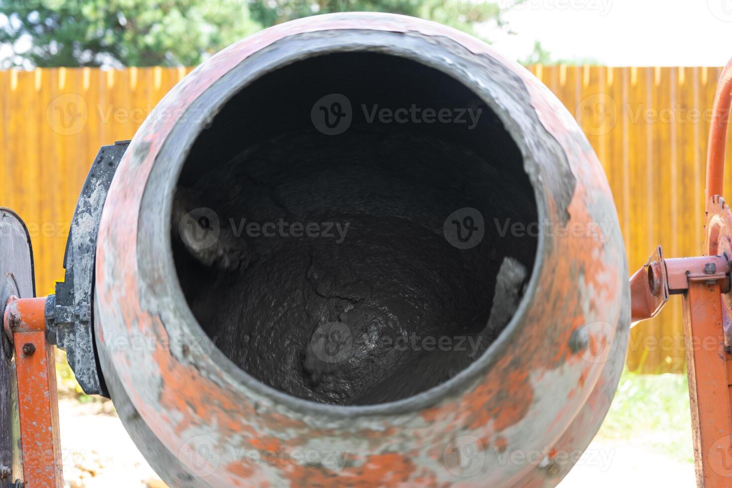 Mixing mortar in a handheld portable concrete mixer photo