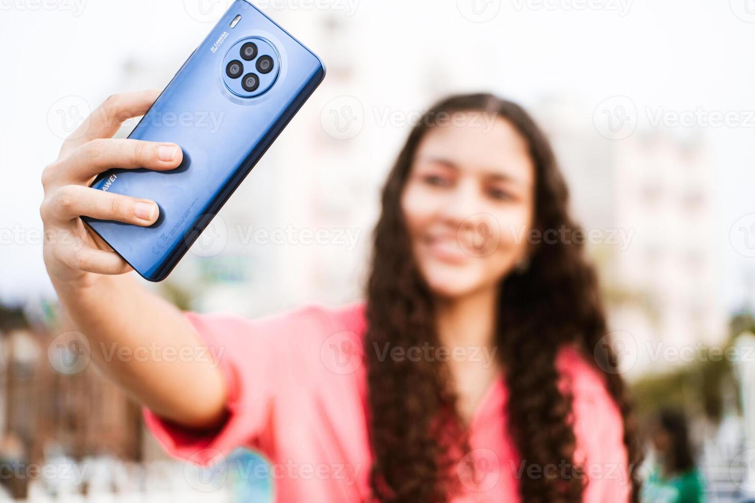 Selective focus of a phone, blurred woman making a with mobile phone. photo
