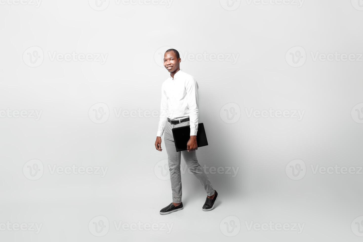 full body of a entrepreneur black man hold laptop go walking isolated background business concept. photo