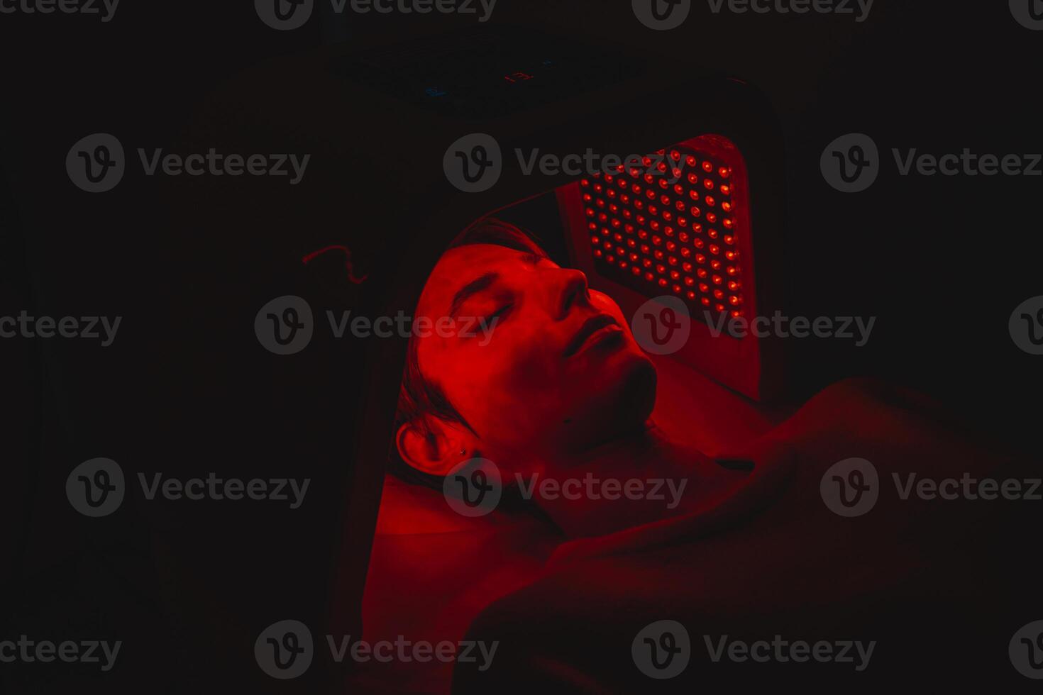 Facial skin care using an LED lamp in a beauty salon. photo