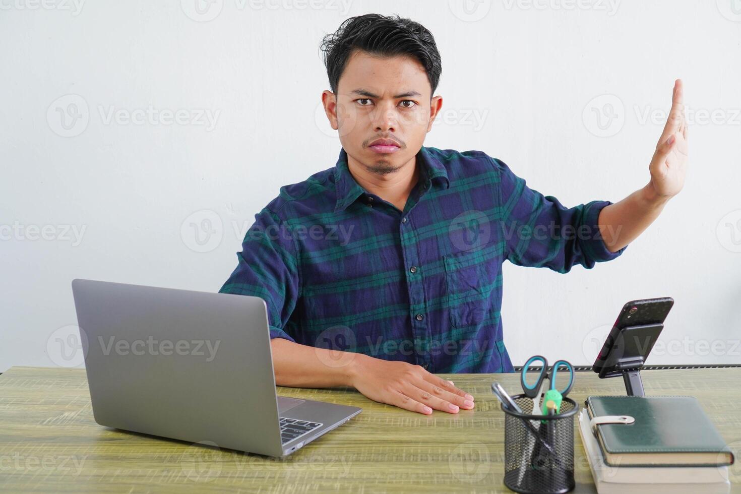 young asian man sit work at wooden desk with pc laptop. Achievement business career lifestyle concept. showing stop gesture aside with palm photo