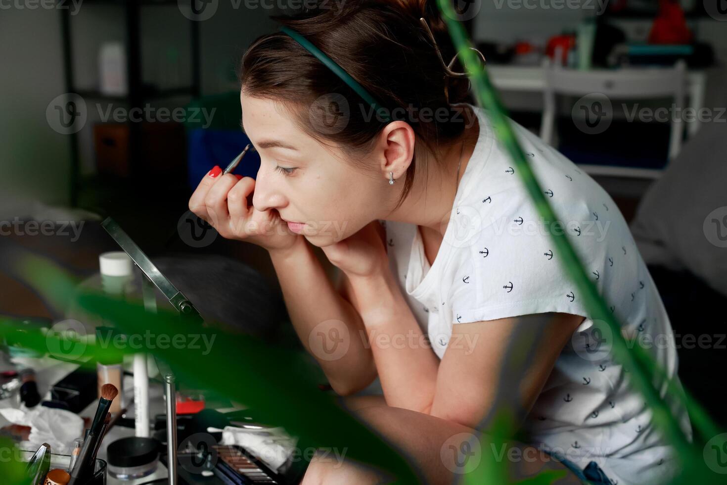 Young girl using brush to apply eyeshadow. Home makeup concept. Getting ready for a party. photo