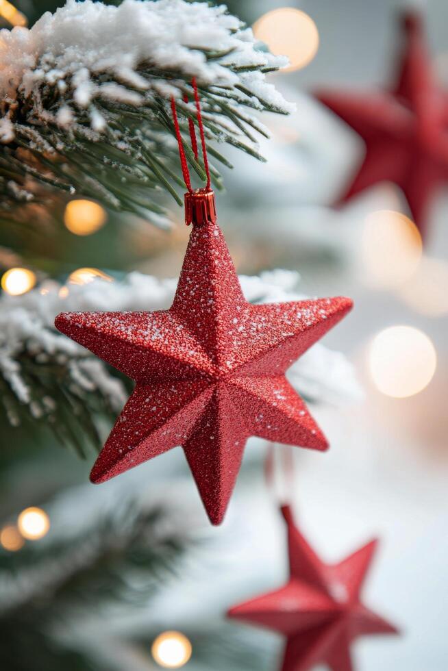 Red star ornament hanging from a Christmas tree decorated with lights and festive ornaments photo