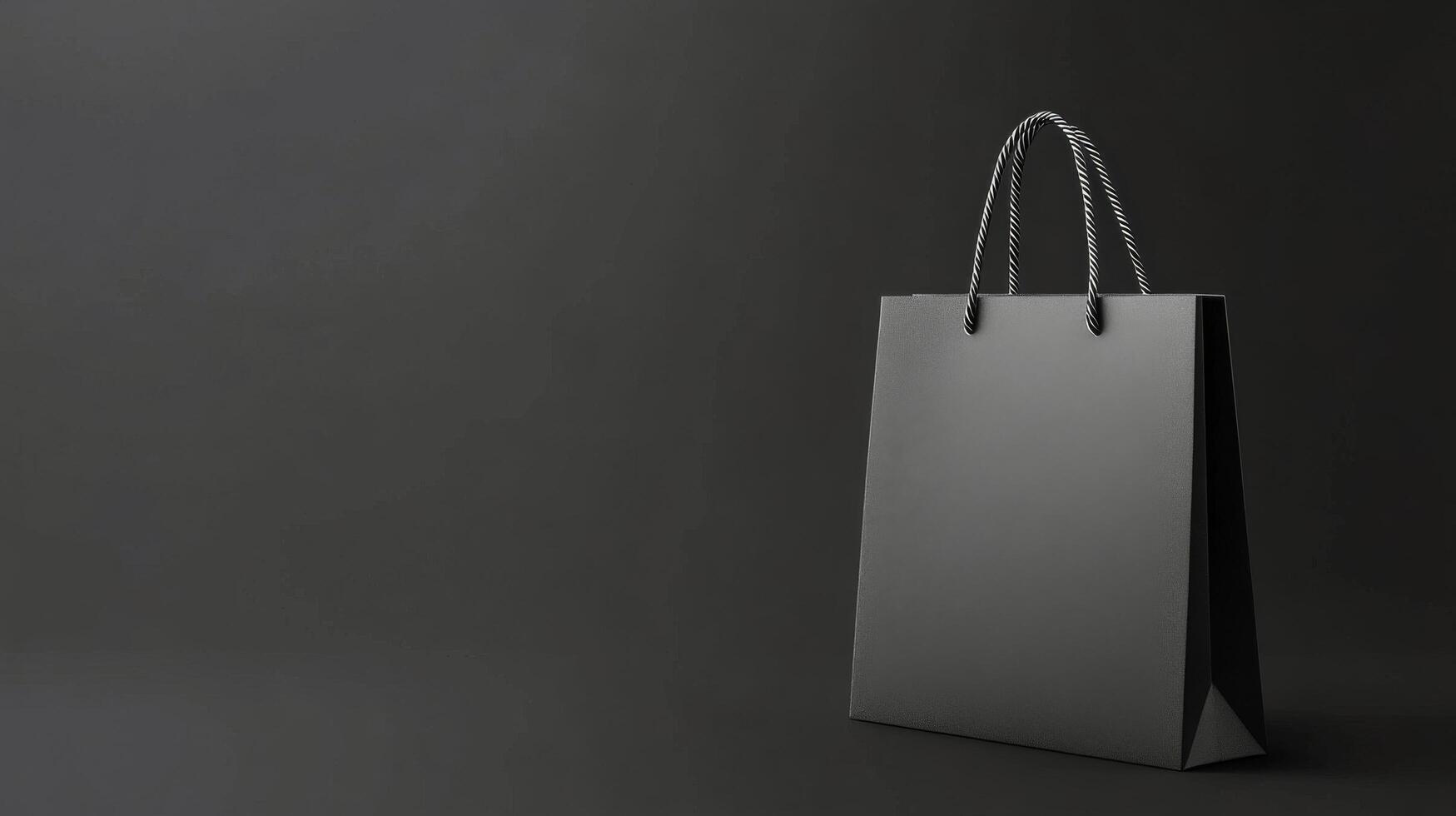 Simple black shopping bag displayed on a dark background highlighting its elegant shape photo