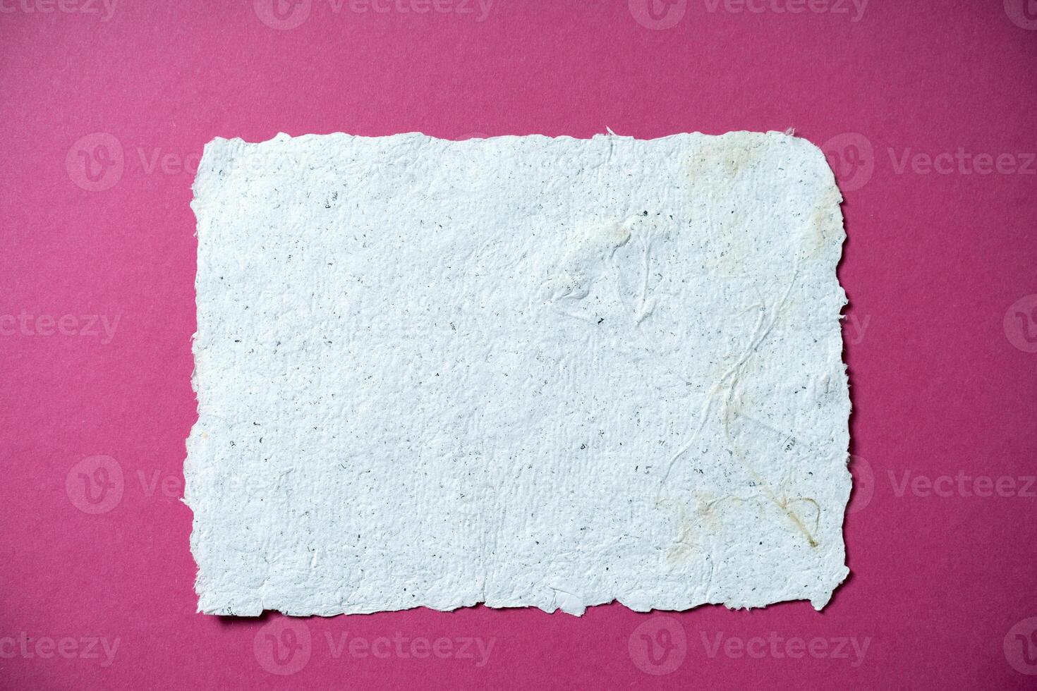 One Sheet of recycled paper on pink background. Secondary production. Making paper with your own hands at home. photo