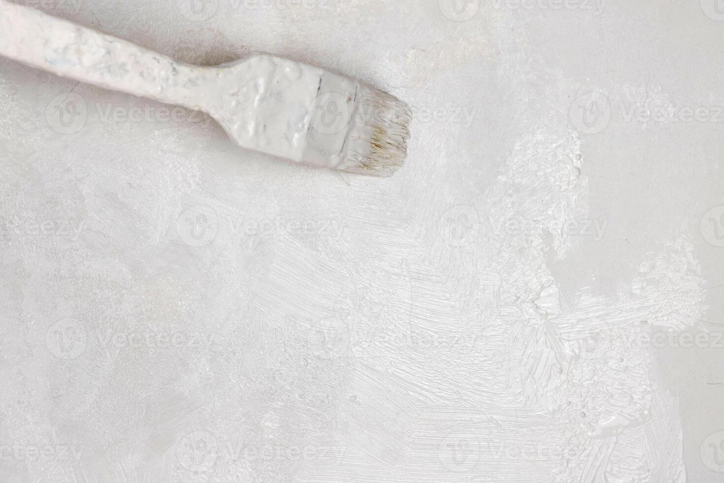 Closeup of a paintbrush applying white paint on a wall, perfect for home renovation and diy projects to give interiors a fresh, clean, and modern look. Minimalistic, bright decor. Copy space. photo