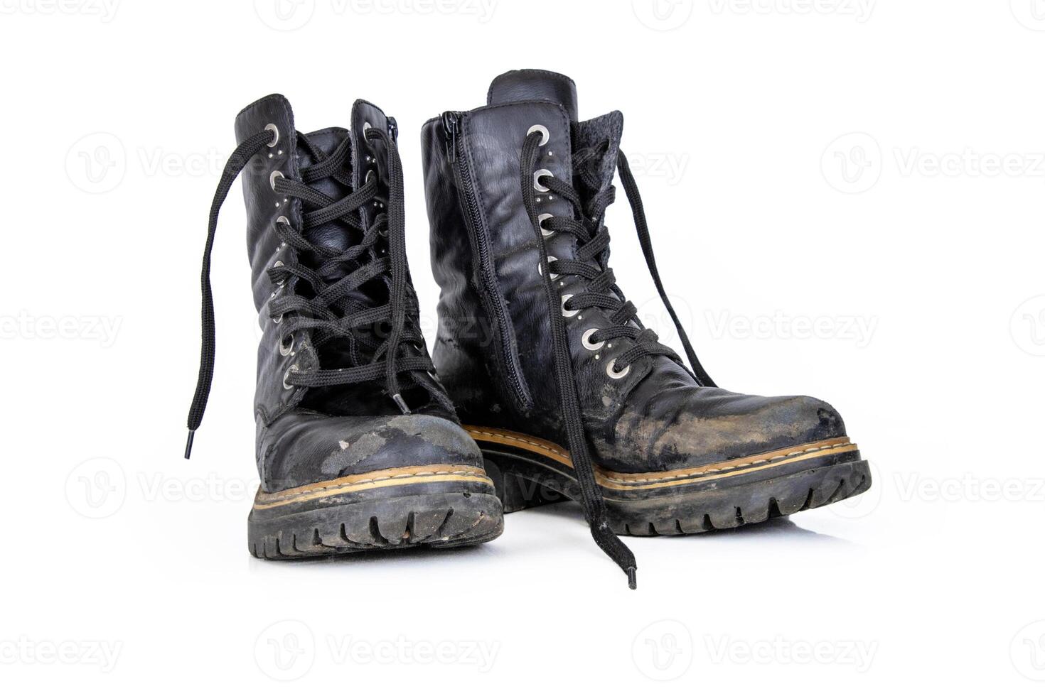Pair of rugged worn black ankle leather combat boots with thick, sturdy soles and laces. Two vintage military style shoes. Studio light. Isolated on white background. Empty copy space. Clipping path photo