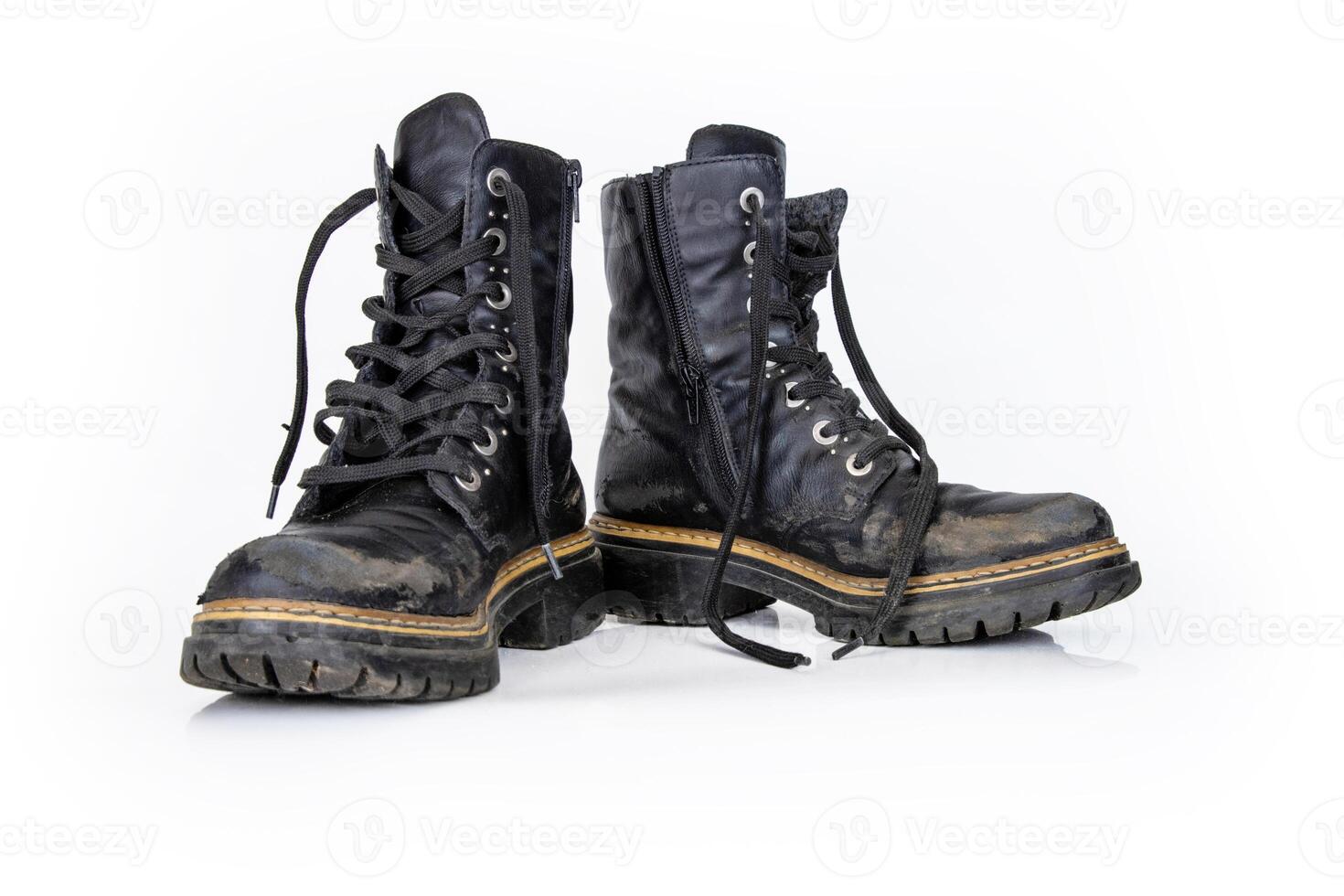 Pair of rugged worn black ankle leather combat boots with thick, sturdy soles and laces. Two vintage military style shoes. Studio light. Isolated on white background. Empty copy space. Clipping path photo