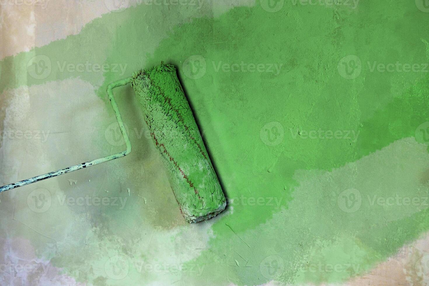 Closeup of a paint roller applying fresh white paint on a wall. DIY process of home renovation and painting for a clean, updated interior. home improvement and wall makeover. Copy space. photo