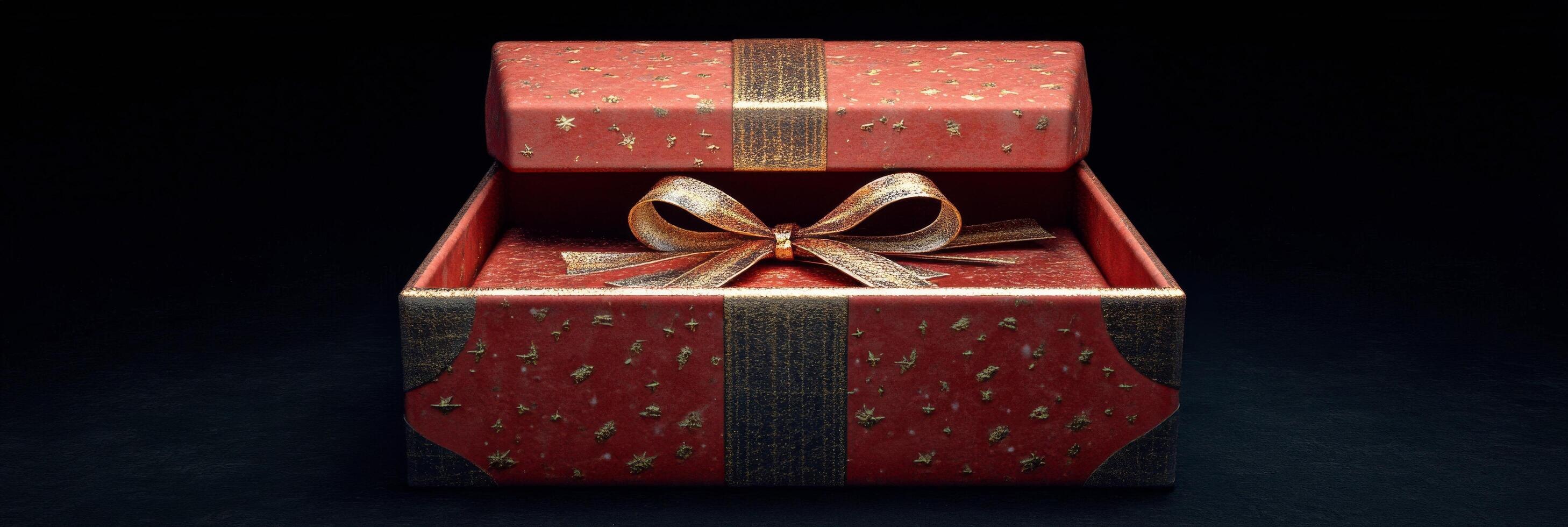 A beautifully wrapped red gift box with a golden bow glowing against a dark background photo