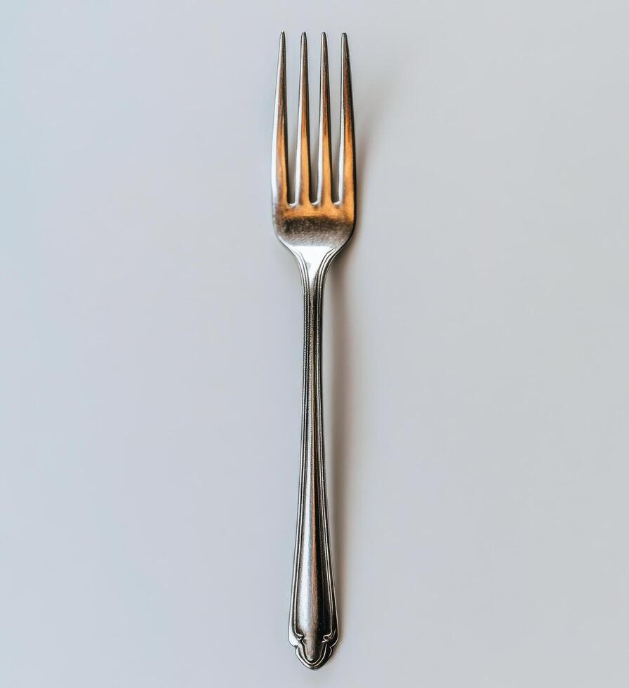 A shiny silver fork placed on a minimalist surface, highlighting its elegant design and shape photo