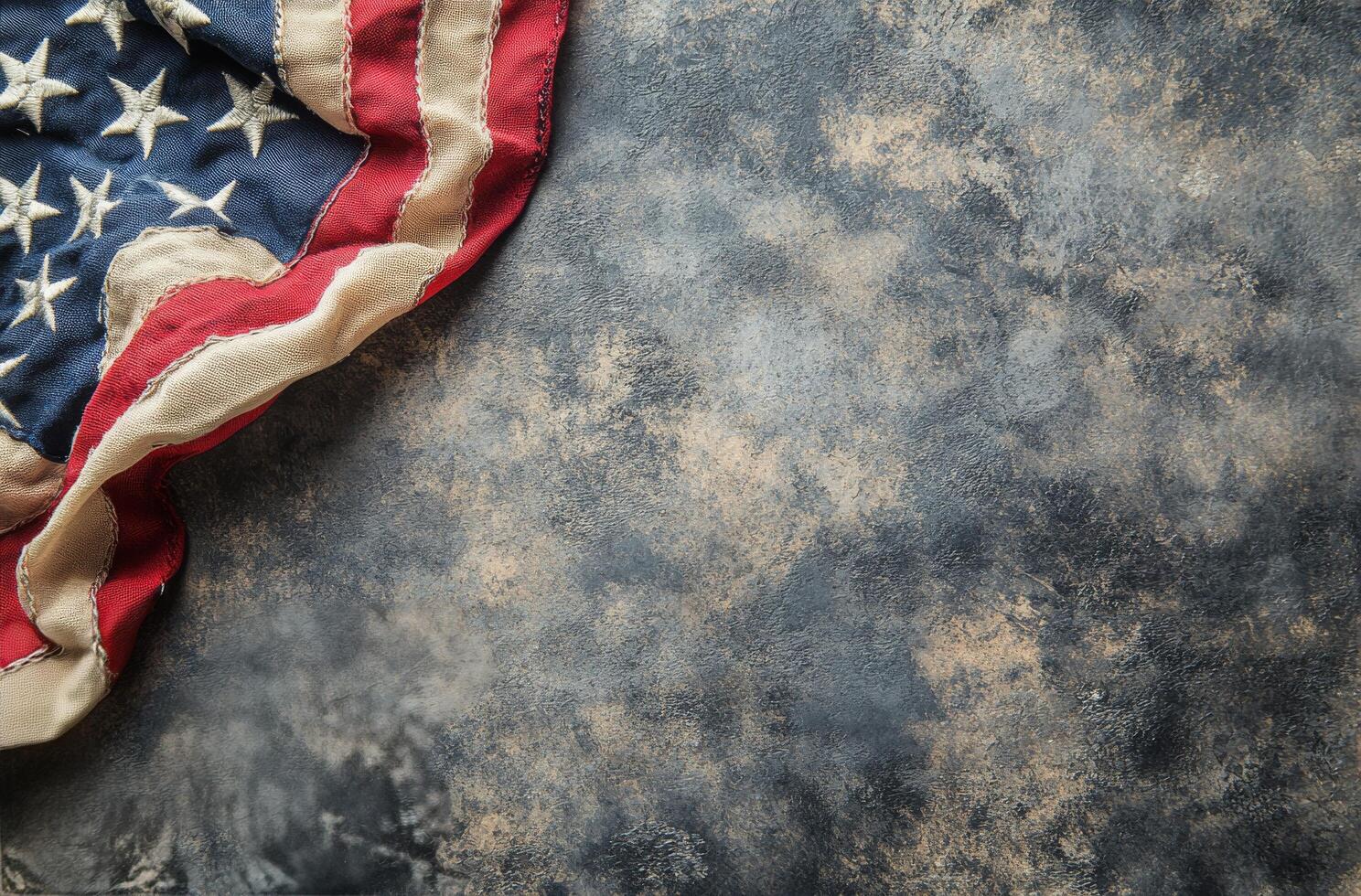 Tattered American flag displaying faded stars and worn fabric against a dark background photo