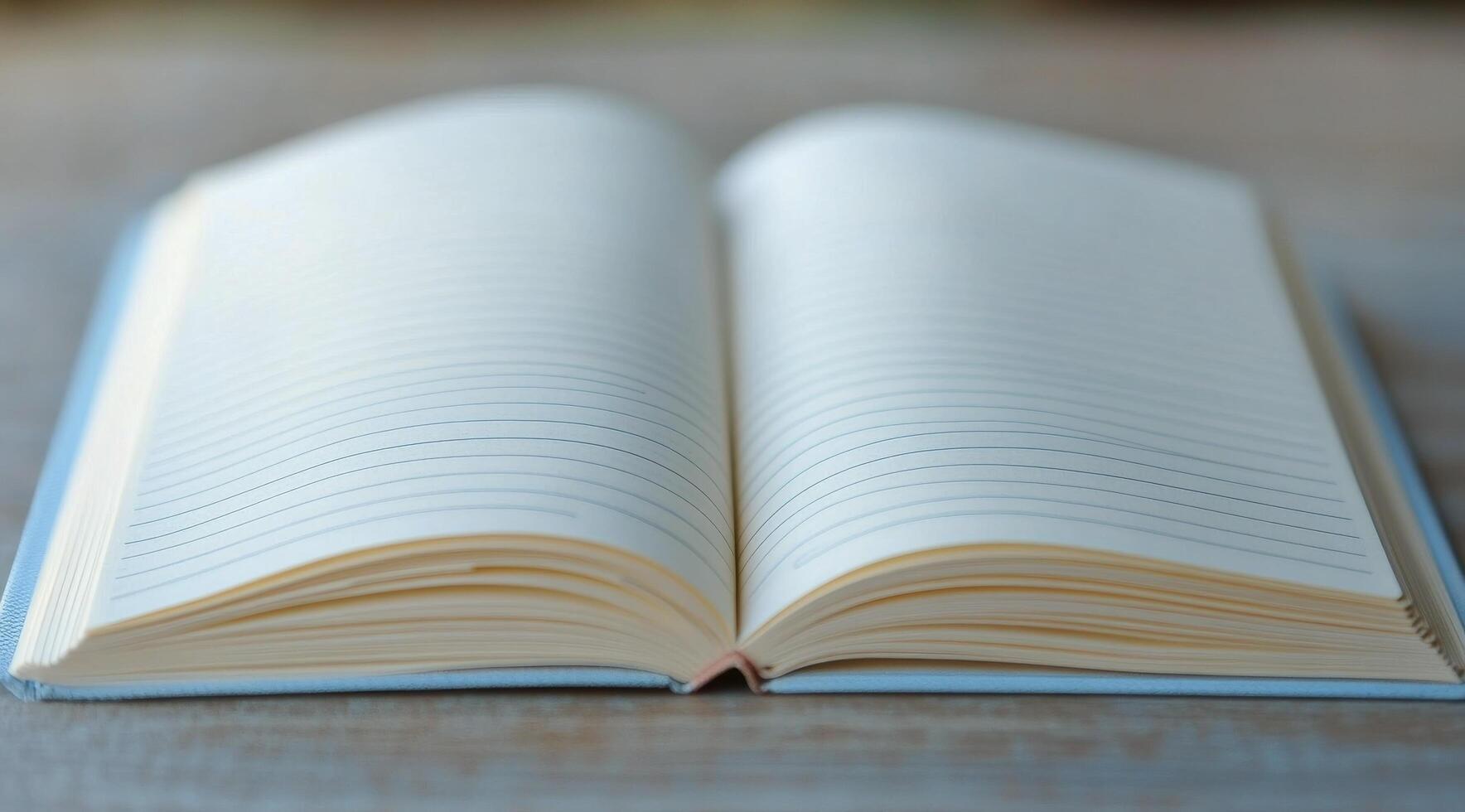 A blank notebook lies open on a blue surface, inviting creativity and ideas to flow freely photo
