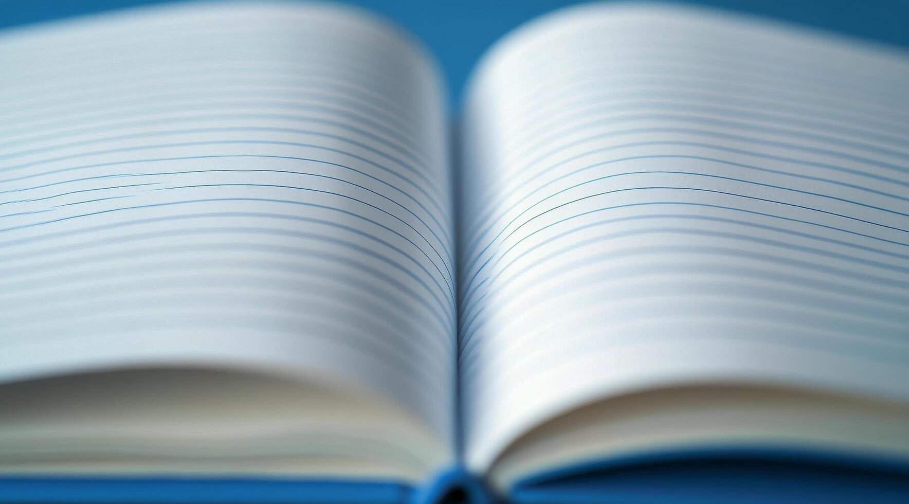A blank notebook lies open on a blue surface, inviting creativity and ideas to flow freely photo