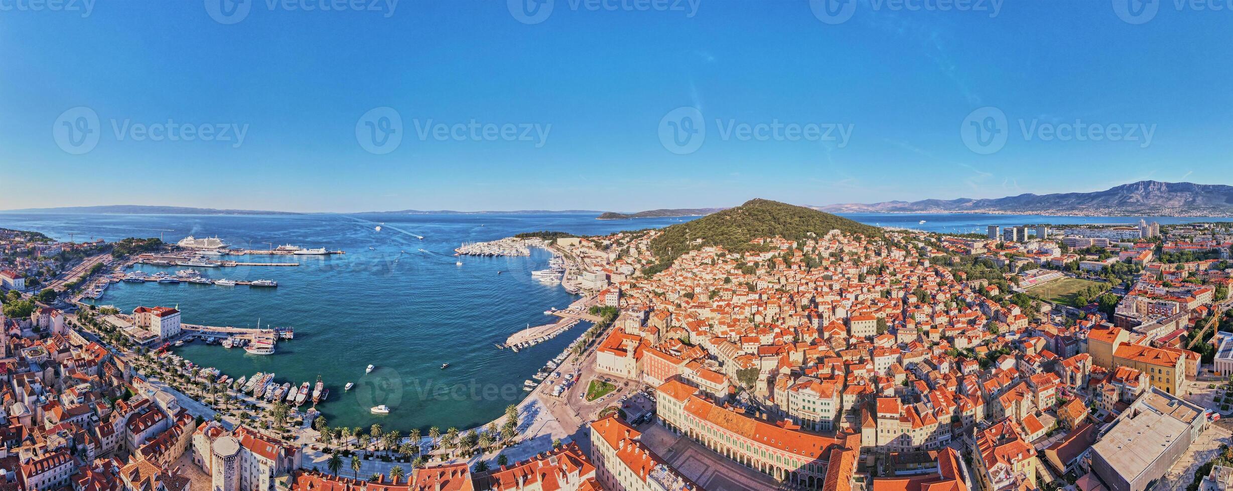 Aerial view of Split, Croatia. Panoramic cityscape of coastal touristic city with harbor. Old town with historical red roof tiled buildings near Adriatic Sea photo