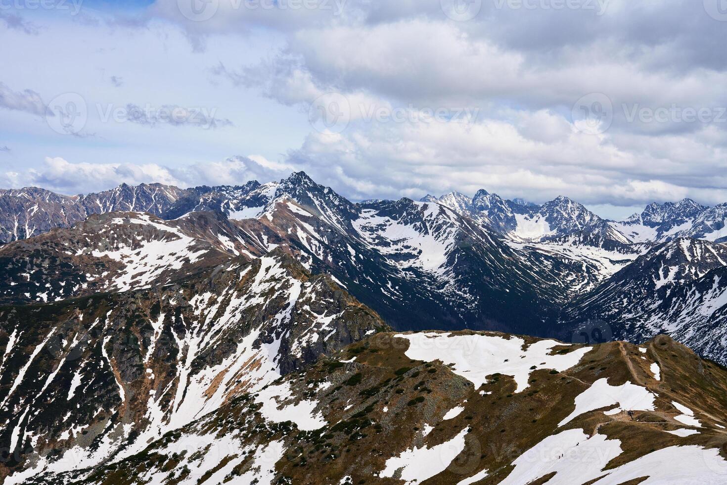 Panoramic view of snow-capped mountain range against cloudy sky. Tatra mountains in Zakopane, Poland. Giewont mountain summit. Natural landscape photo