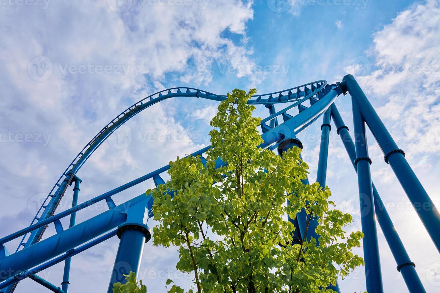 Roller coaster attraction in amusement park. Entertainment at summer holiday photo