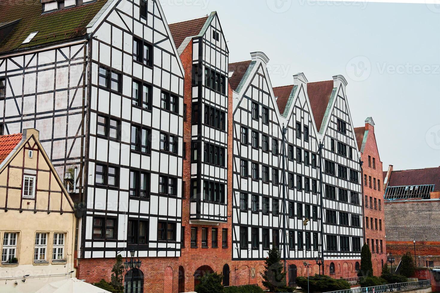 Row of colorful half timbered buildings with gabled roofs in old town of Gdansk, Poland. Living house facade with balconies. Apartment building. Mortgage in real estate photo