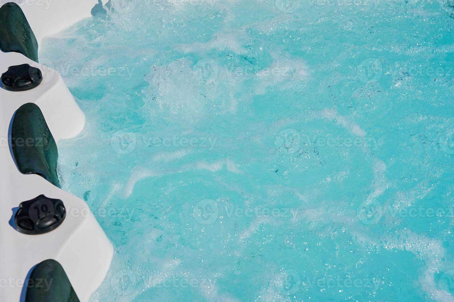 Close-up shot bubbling water in hot tub with headrests photo