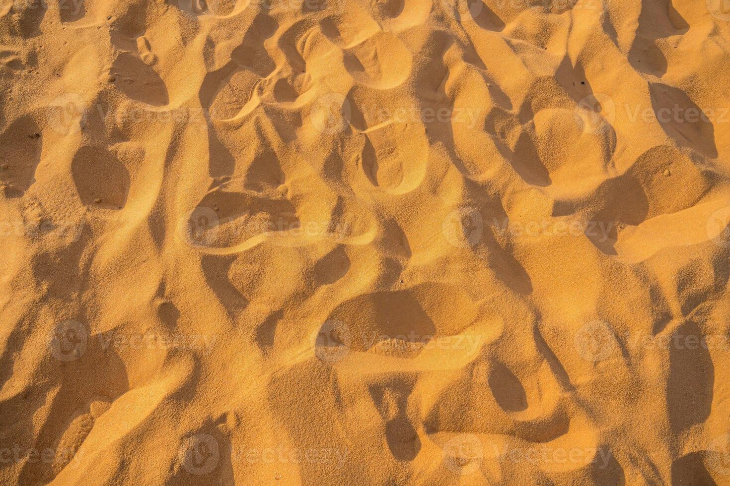 Close up of sand pattern of a beach in the summer. Sand texture background. Brown desert pattern from tropical beach. photo