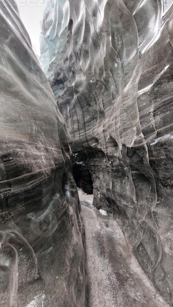 Ice tunnels with visibly shattered glacier rocks at Vatnajokull iceberg. Ice caves pathways with icy chunks used for glacier hiking next to gorgeous cracked blocks of ice. photo
