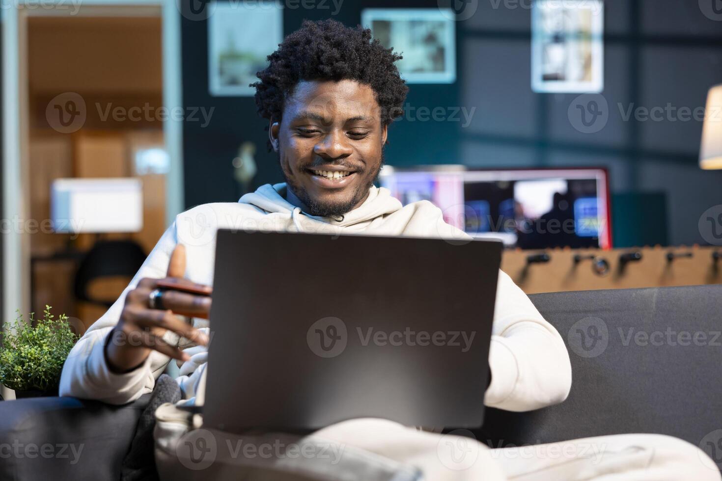 Man feeling excited after receiving salary, adding payment method on website, looking at debit card info. Buoyant self employed man delighted to do online shopping, looking to do acquisitions photo