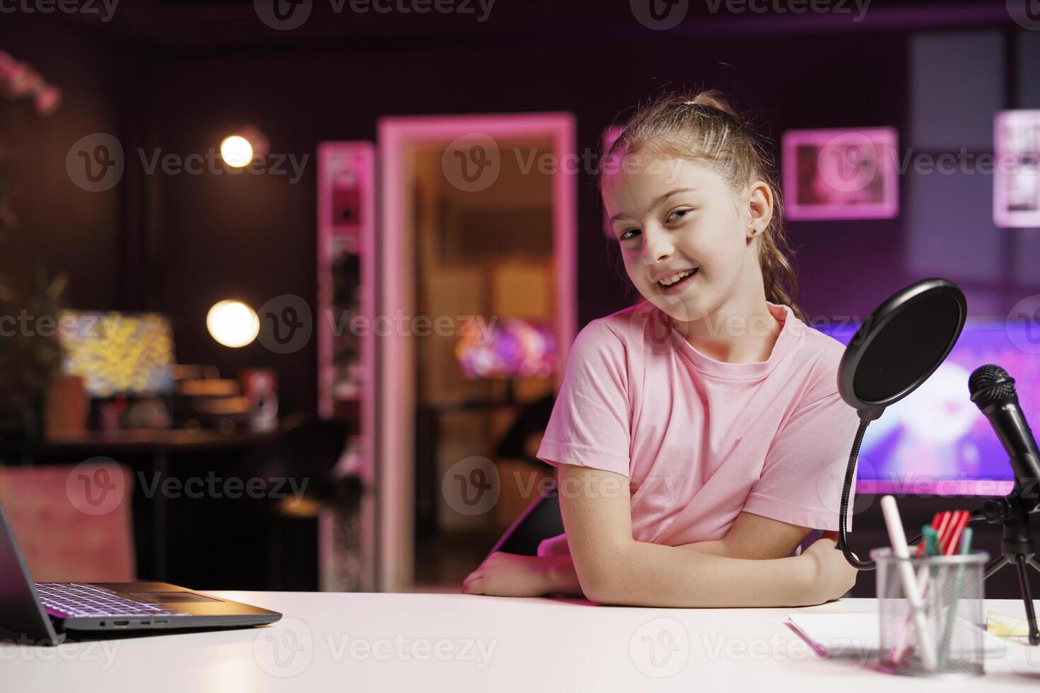 Happy child doing content creation, using professional recording equipment to film vlog channel intro. Young internet star greets children subscribers, presenting today topic photo