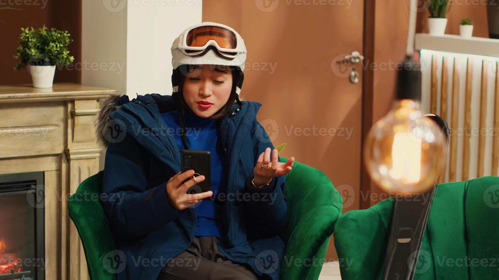 Guest texting messages on phone, asking friends to meet skiing on slopes at mountain complex. Winter sport enthusiast checking smartphone app and social media before leisure activity. photo
