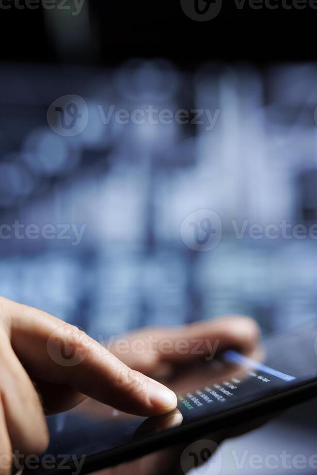 Close up of certified system administrator updating server rigs, writing intricate binary code scripts on tablet. Computer scientist using programming to fortify cybersecurity in high tech place photo