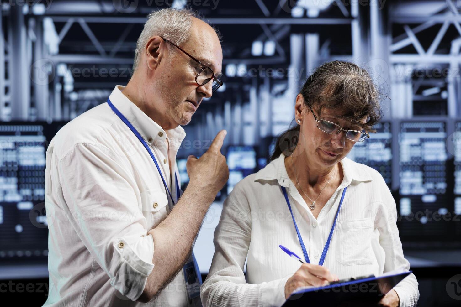 Aged wiremen brainstorming ways to repair server farm components. Skilled electricians brainstorming ideas on how to best minimize high tech facility downtime and prevent data loss photo