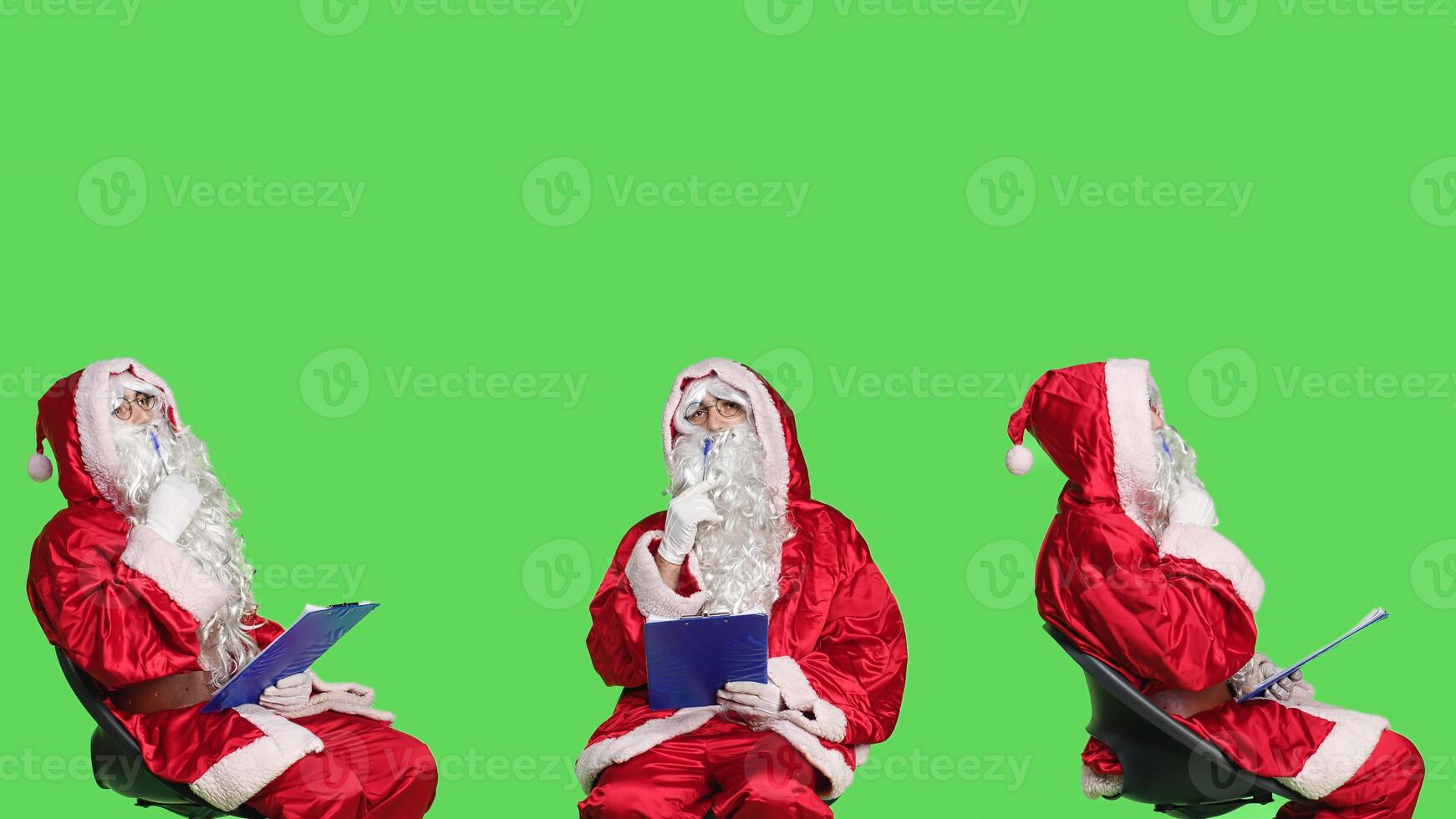 Saint nick character taking notes using clipboard papers while he sits on chair in festive red costume. Adult portraying santa claus and writing information about children, holiday concept. photo