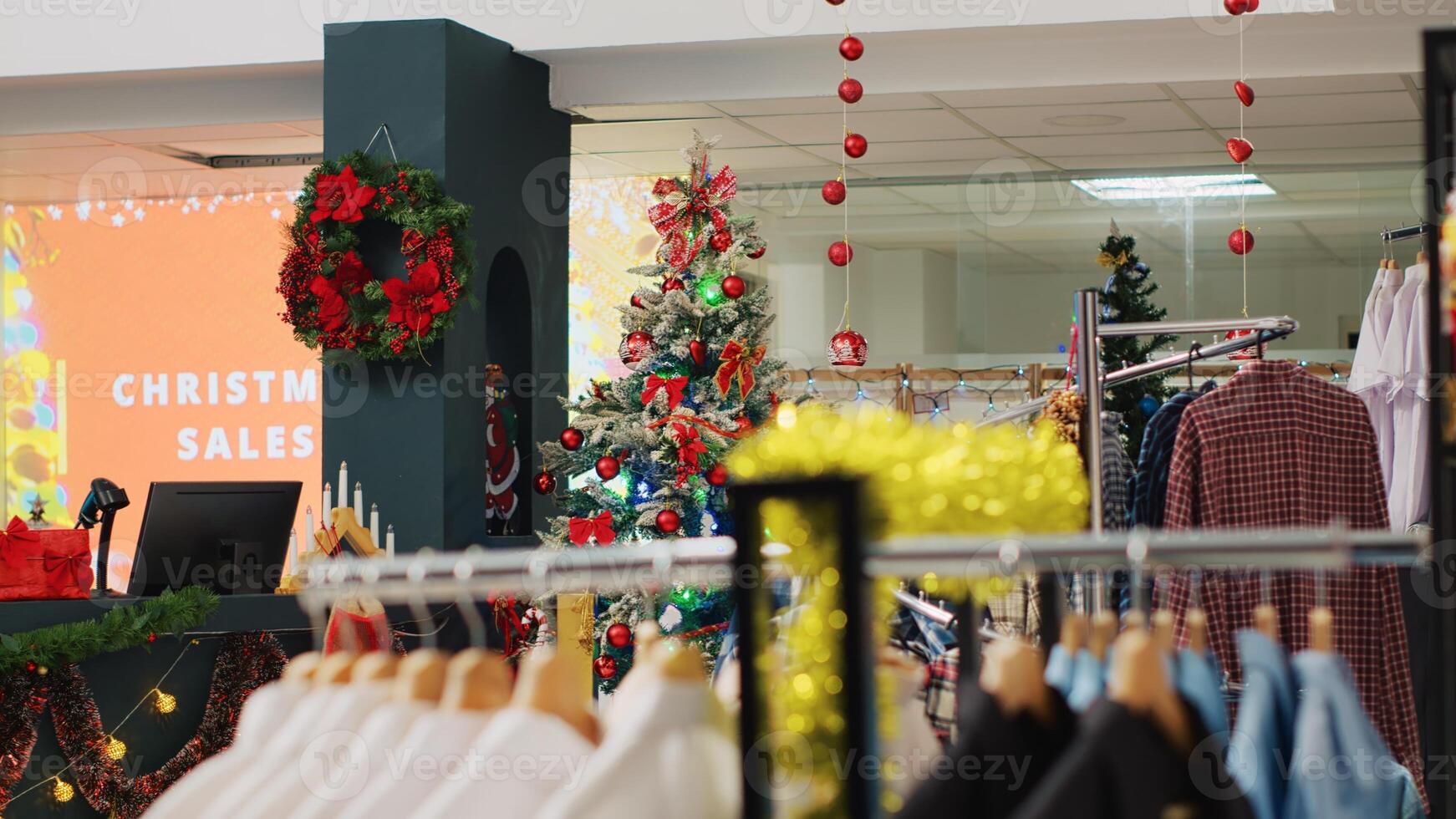 Festive Christmas decorated store with wide variety of clothing on sale and bargains for holiday shopping. Mall fashion boutique adorn with xmas ornaments and formal attire racks photo