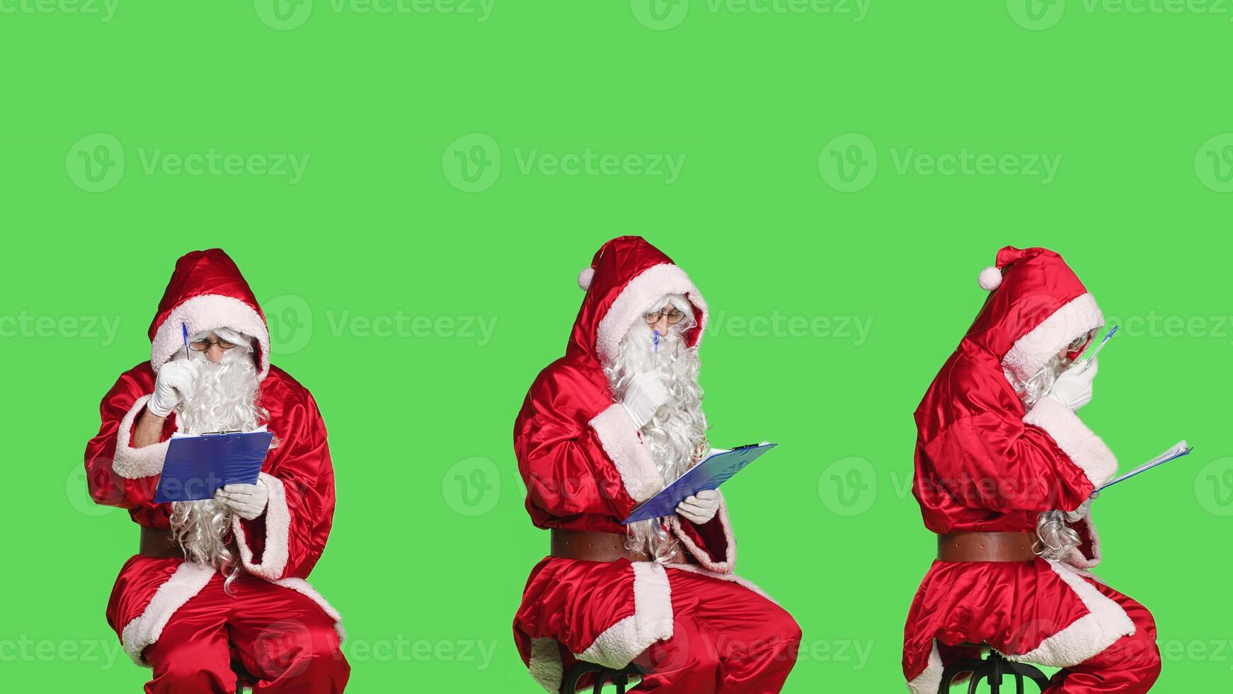Man santa claus write on papers, sitting on chair while he is creating naughty and nice list for presents. Father christmas preparing for seasonal winter celebration of xmas, greenscreen. photo