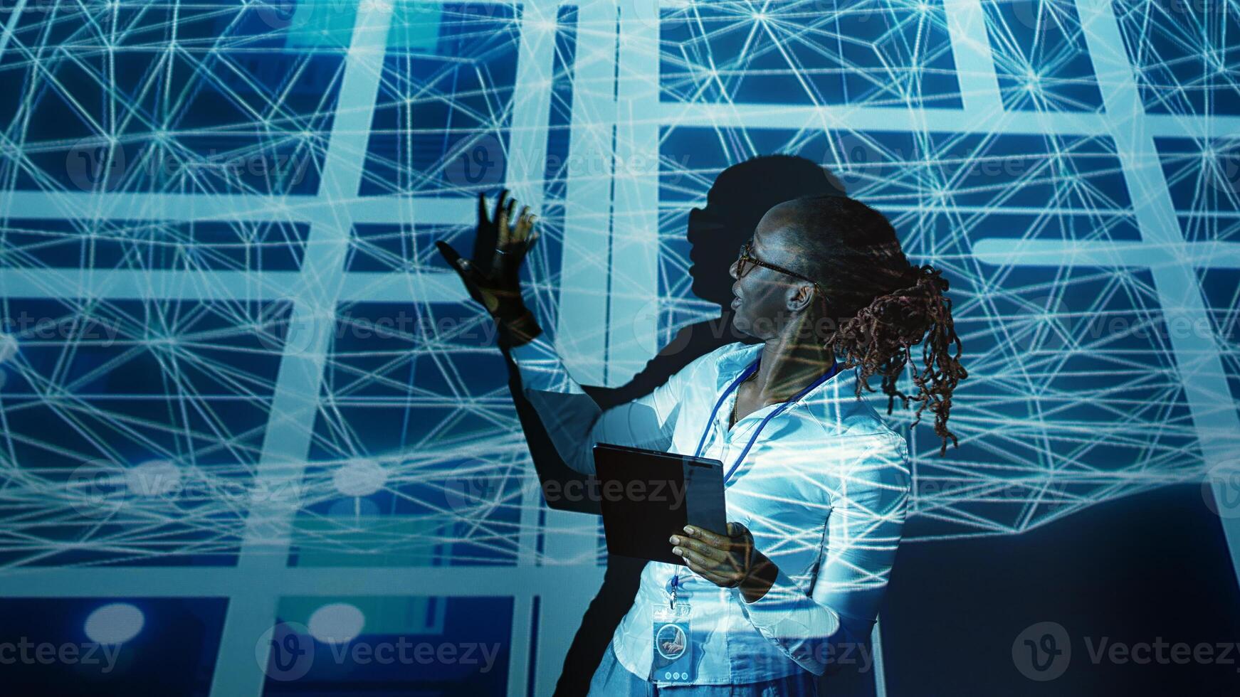 Computer scientist programming in AI server farm housing advanced equipment used for machine learning training. Developer running code on tablet to upgrade artificial intelligence rigs photo