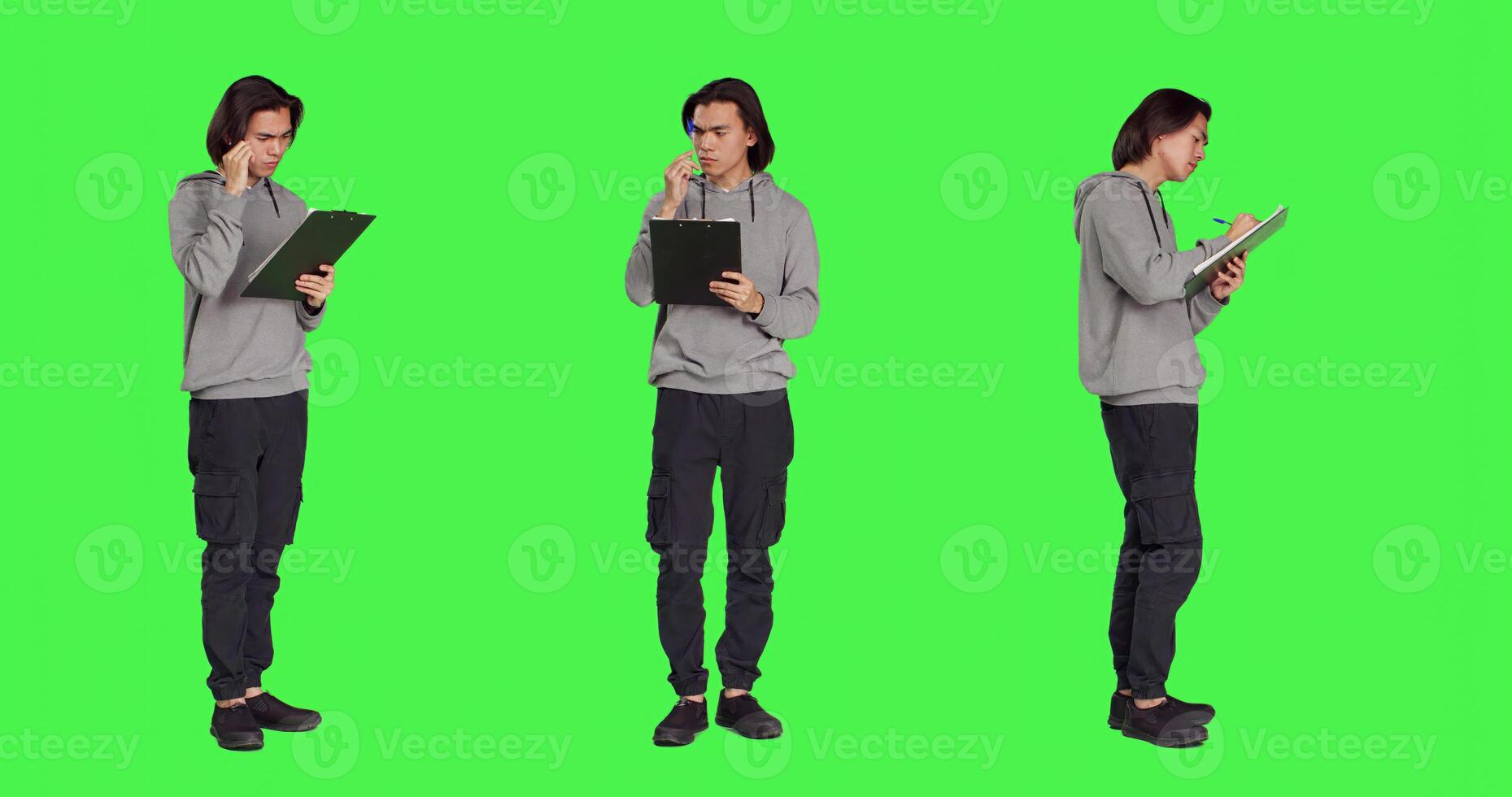Asian adult taking notes and thinking about ideas to write on clipboard files, using papers for inspiration on camera. Person being pensive and in doubt, writing information in studio. photo