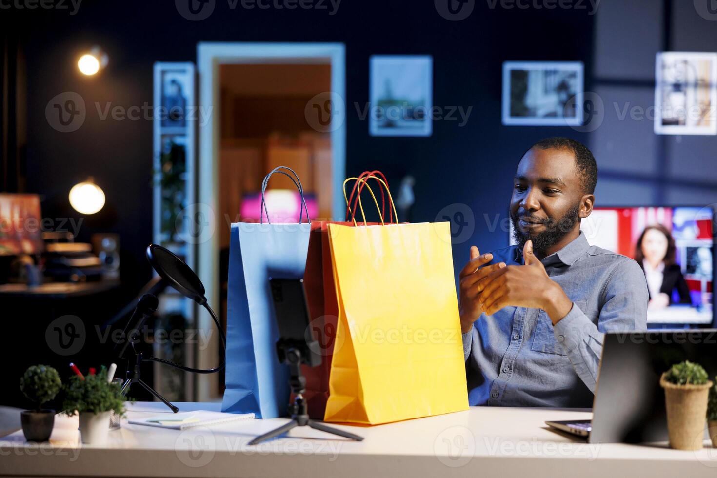 African american content creator filming vlog, unboxing bags with internet order, showing subscribers purchases he recently got. Fashion enthusiast presenting fans shopping acquisitions photo