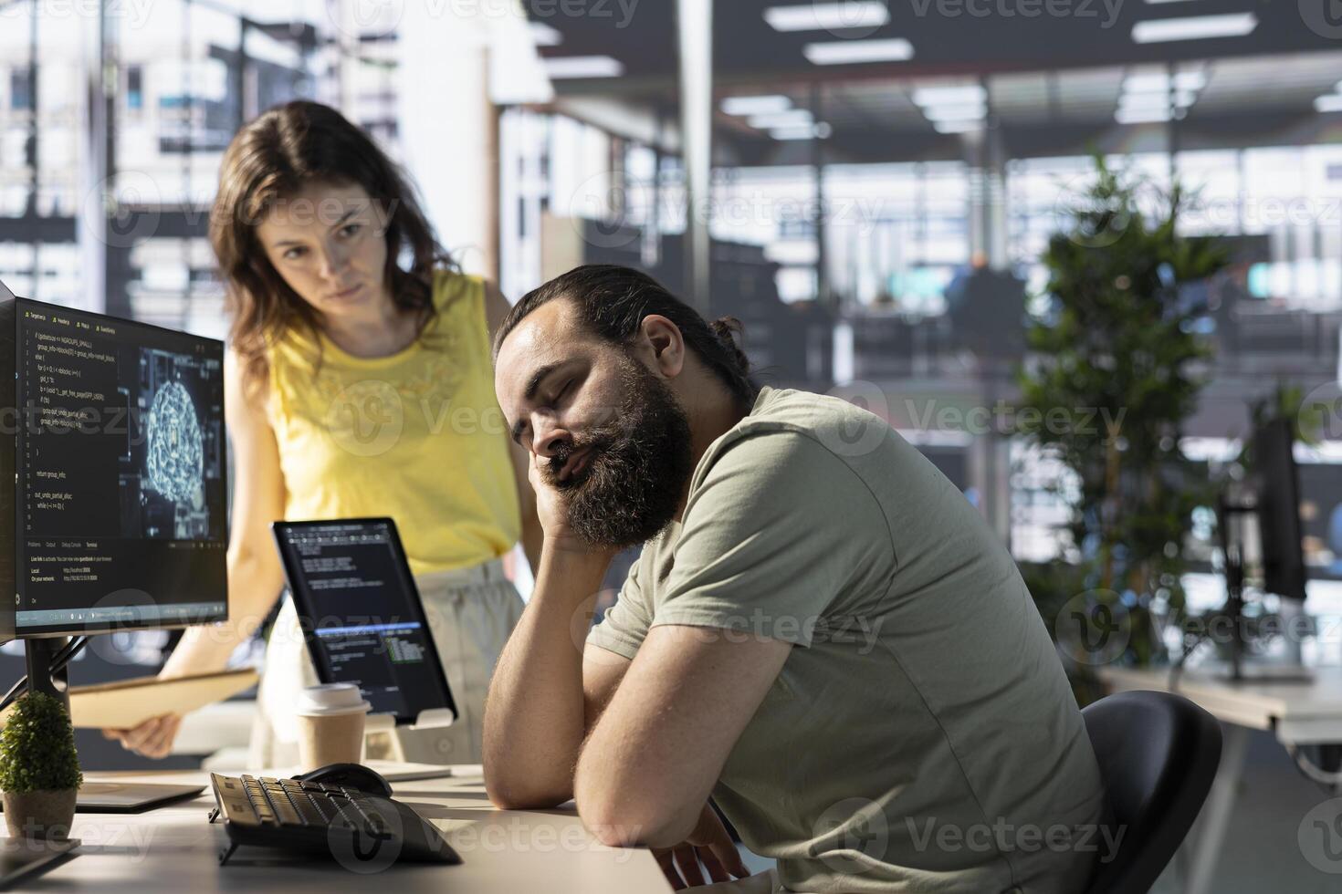 Programmer caught asleep at desk by manager while developing AI machine learning APIs solving complex problems. Tired sleeping man woken up by team leader while training predictive models photo