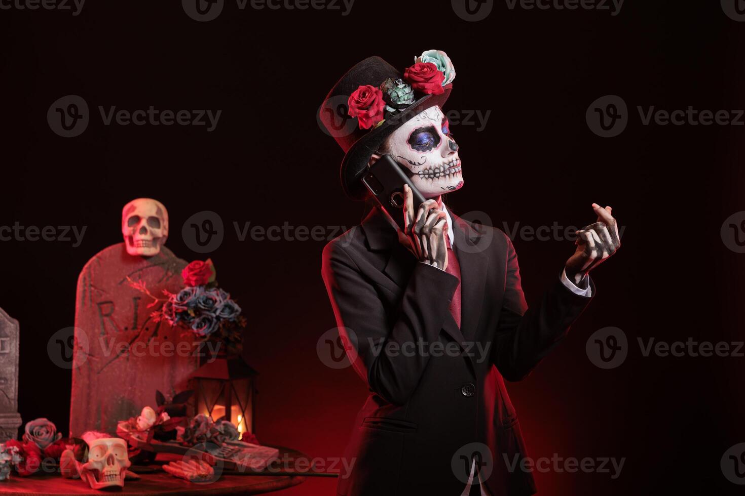 Woman doing telephone call during Dia de los Muertes indigenous rites of honoring the dead. Lady talking on phone, participating in Day of the Dead, Mexico annual event in honor of the deceased photo