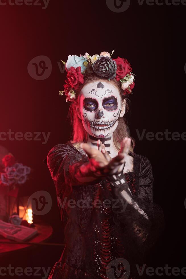 Woman doing enticing invitation hand gesture at Day of the Dead event to remember the deceased. Lady doing seducing wooing gesturing during Mexican holiday of remembrance for those who have passed photo